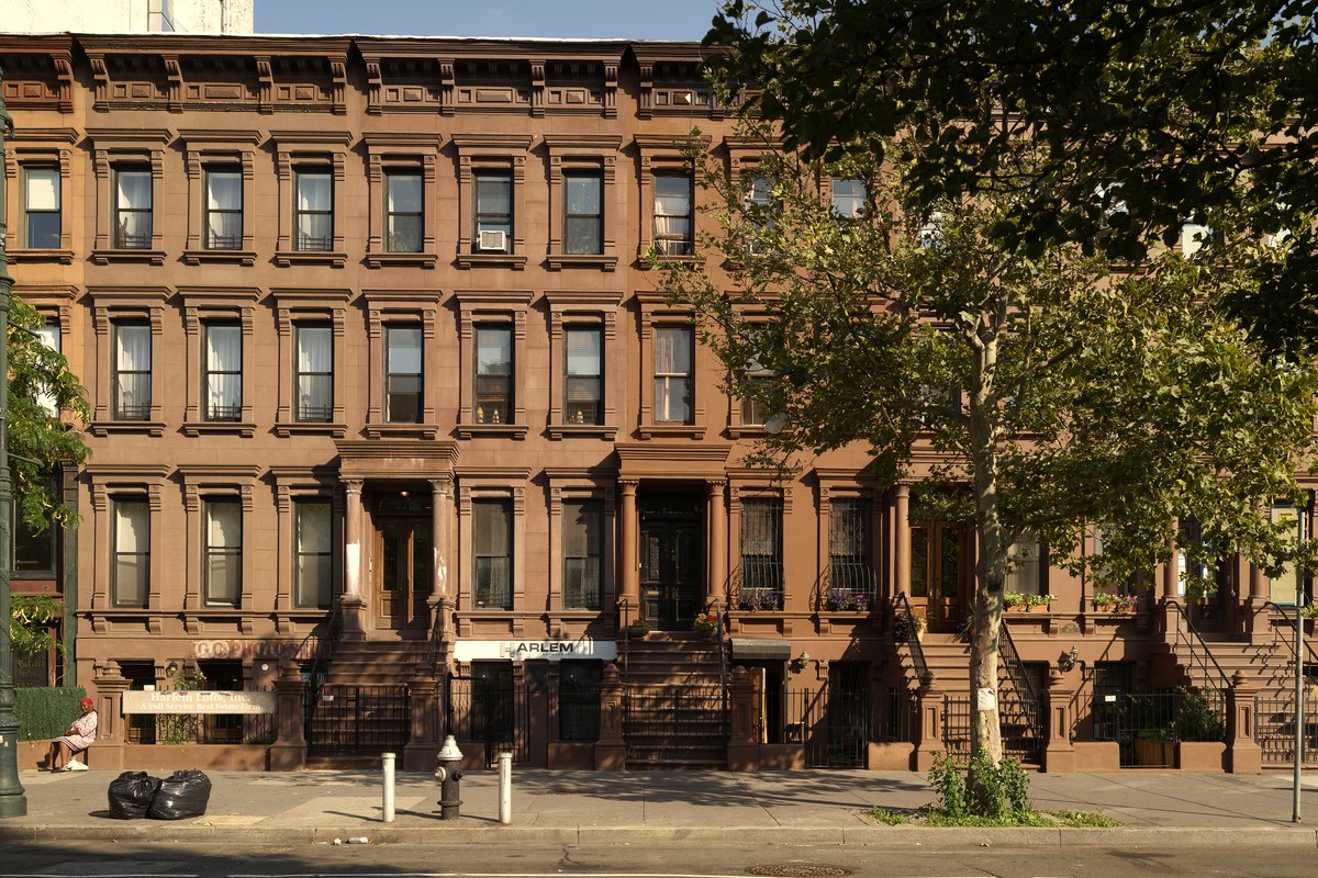 A brownstone apartment building in Harlem, New York City, seen from street level