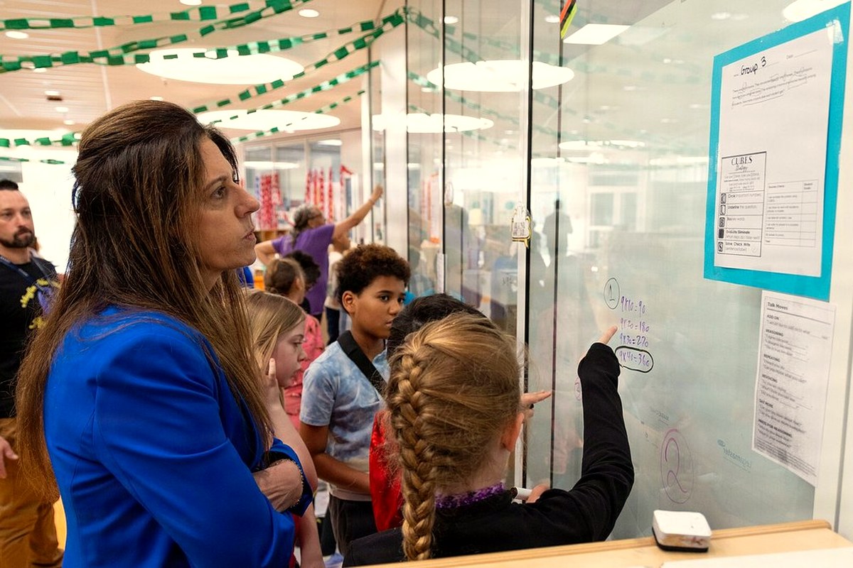 Students working together at a glass wall in a bright modern school